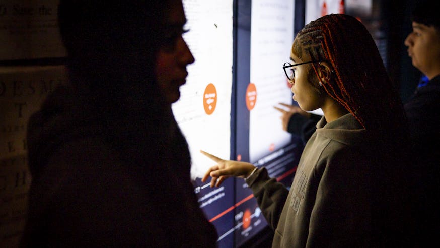 A student uses the Posters of Protest touchscreen interactive in the Museum's core exhibition.