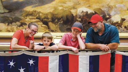 Annual Report Cover Photo of family looking at the True Colours flags.