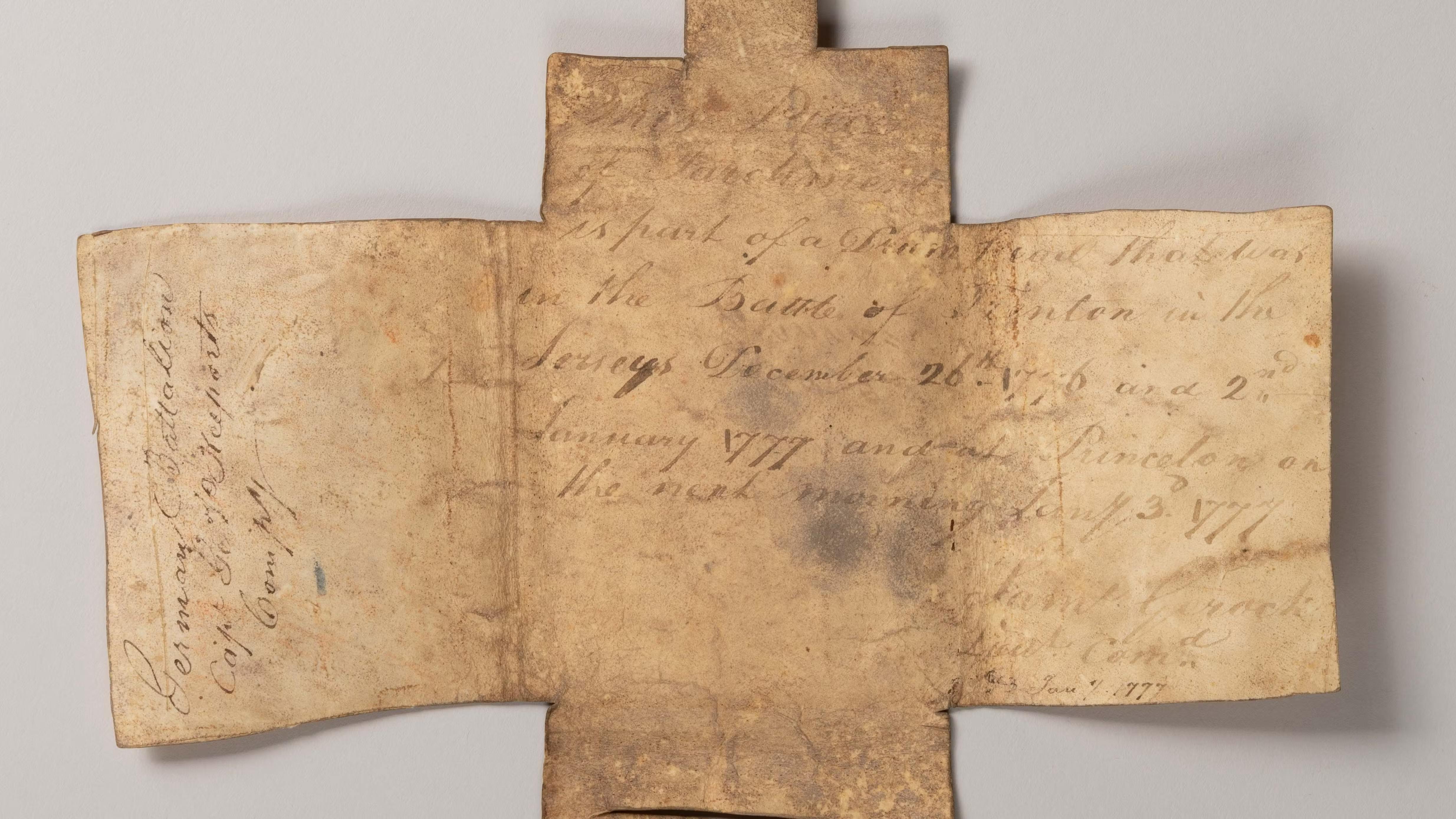 This image shows a brownish beige leather wallet opened to show writing on the inside.